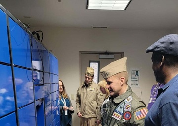 NAS Fallon Commanding Officer Capt. Shane Paul Tanner participates in a demonstration of the Intelligent Mail Locker in the NAS Fallon BEQ.