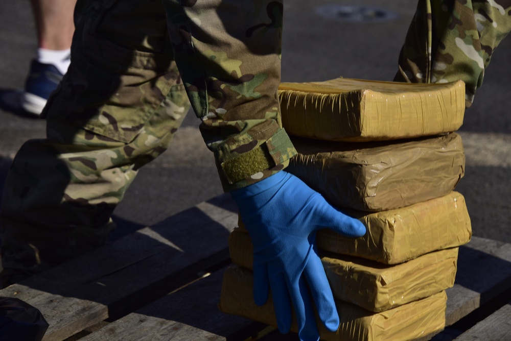A member of U.S. Coast Guard Law Enforcement Detachment 406 offloads interdicted narcotics aboard USS Farragut (DDG 99) in Port Everglades, Florida, April 4, 2023. The offloaded drugs were seized from four go-fast smuggling interdictions by crew members of Coast Guard LEDET 406, Navy Combat Element (CEL) and Helicopter Maritime Strike Squadron Six Zero (HSM-60) in the Eastern Pacific Ocean. (U.S. Coast Guard photo by Petty Officer 2nd Class Laticia Sims)
