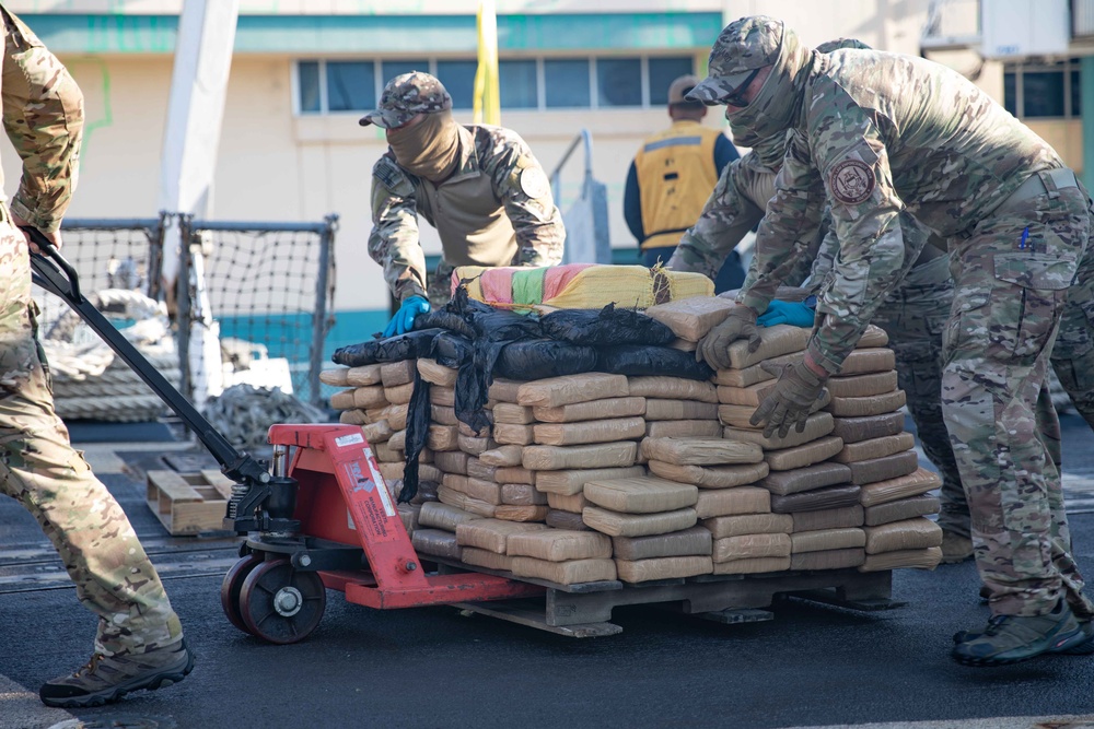 Members of U.S. Coast Guard Law Enforcement Detachment 406 push bales of illegal narcotics aboard USS Farragut (DDG 99) for a drug offload in Port Everglades, Florida, April 4, 2023. The offloaded drugs were seized from four go-fast smuggling interdictions by crew members of Coast Guard LEDET 406, Navy Combat Element (CEL) and Helicopter Maritime Strike Squadron Six Zero (HSM-60) in the Eastern Pacific Ocean. (U.S. Navy photo by Mass Communication Specialist 2nd Class Chelsea Palmer)