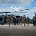 Logistics experts board a helicopter for an island flyover