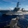 USS Carl Vinson (CVN 70) Fueling-at-sea A U.S. Navy Arleigh Burke-class guided-missile destroyer bearing hull number 63 is underway at sea in open ocean conditions. The warship is photographed from the deck of another vessel, showing the destroyer cutting through blue waters with a white wake. Crew members are visible on the deck of the destroyer, and various radar and weapons systems are visible on the superstructure.