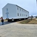 Continuing making history: Contractors move last two World War II-era barracks to new locations