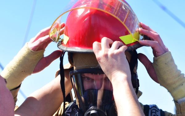 USCGC Eagle personnel don firefighting equipment during a drill while underway in the Atlantic Ocean