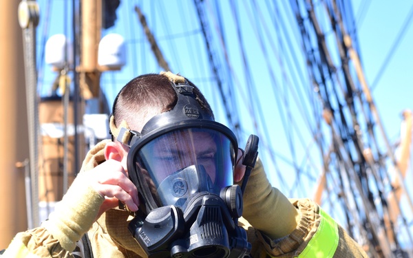 USCGC Eagle personnel don firefighting equipment during a drill while underway in the Atlantic Ocean