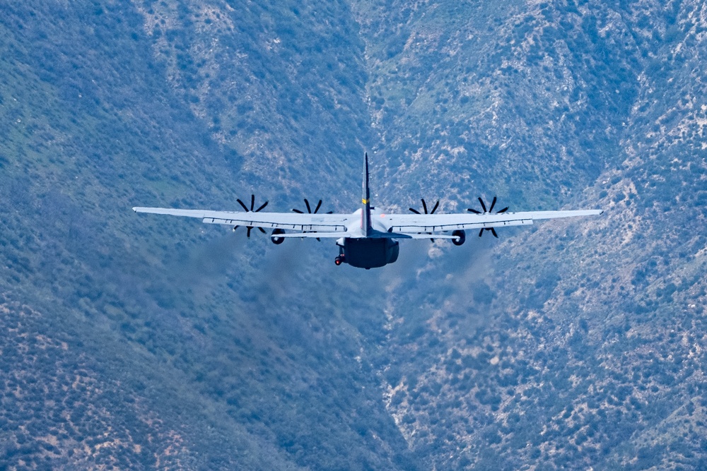 A C-130 from Wyoming Air National Guard's 153rd Airlift Wing flying thru a canyon during Modular Airborne Fire Fighting System (MAFFS) Spring Training 2023