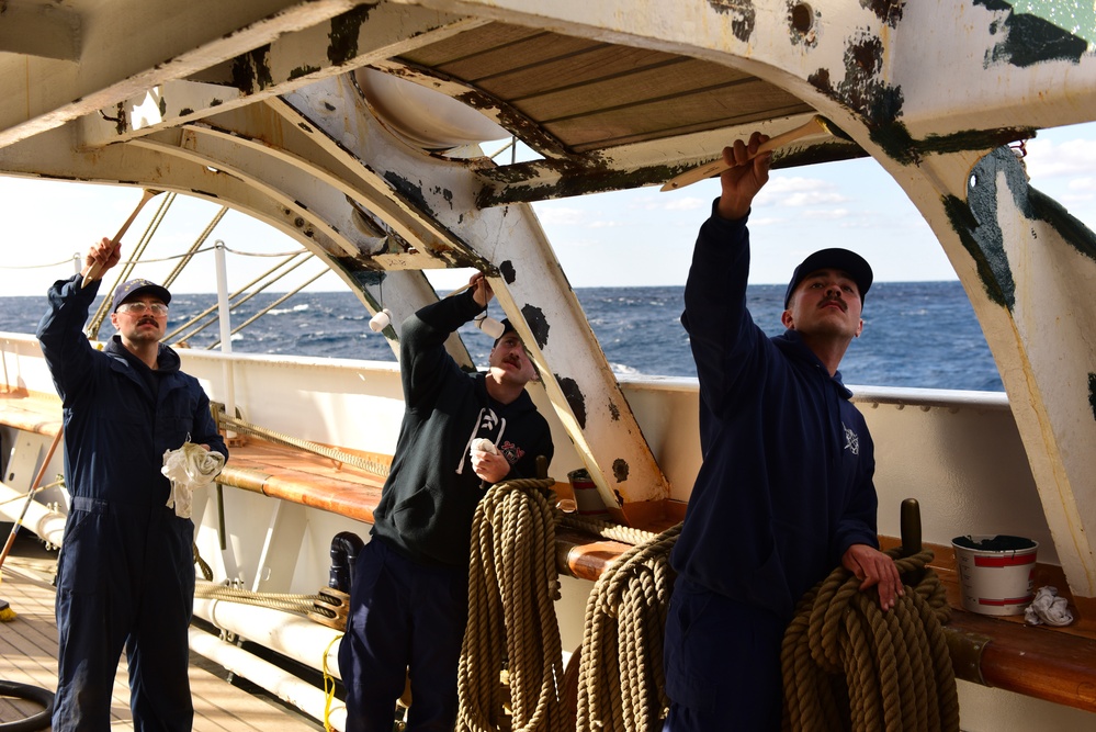 USCGC Eagle personnel perform maintenance to cutter’s surfaces