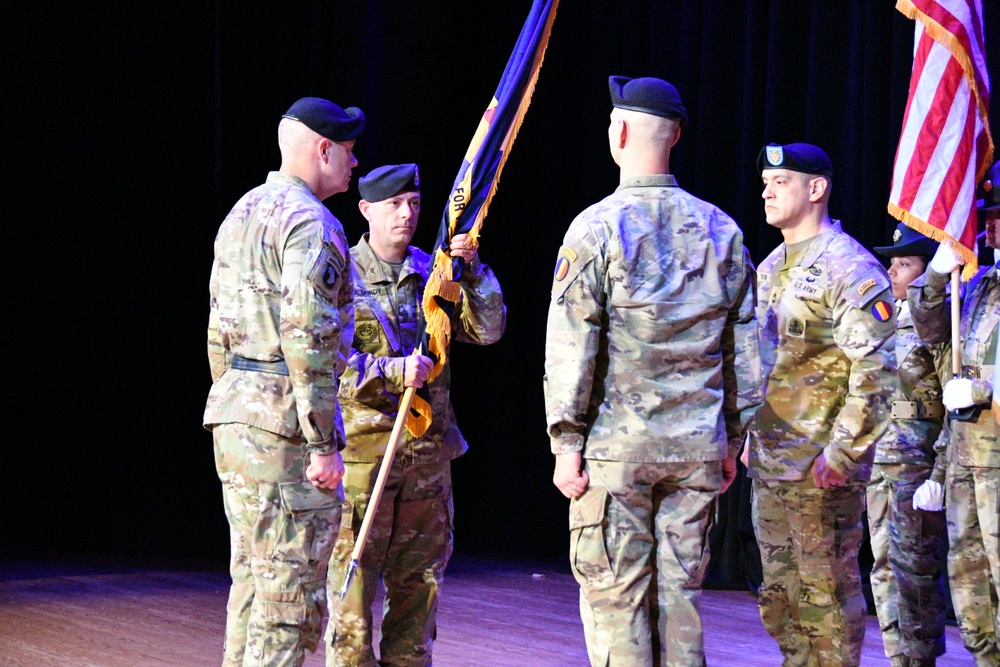 Command Sgt. Maj. Scott Beeson, the outgoing senior enlisted advisor for the U.S. Army Center for Initial Military Training, hands the unit colors one last time to Maj. Gen. John Kline during a Change of Responsibility ceremony at Fort Eustis April 12.