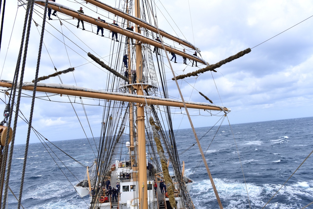 USCGC Eagle personnel conduct sail preparations while underway in the Atlantic Ocean