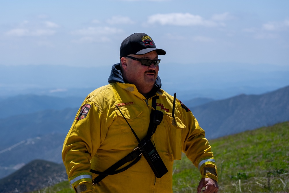 Fire Captain Matt Mihalco from CAL FIRE assists military public affairs during Modular Airborne Fire Fighting (MAFFS) spring training April 14, 2023