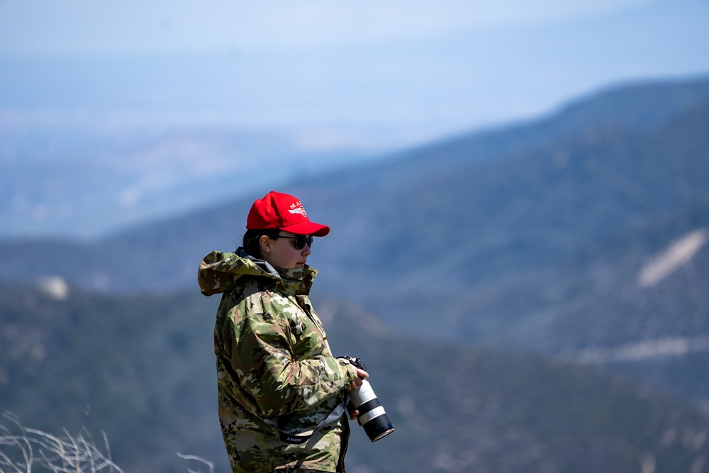 A Public Affairs Specialist atop a hill near Green Valley, Calif. April 14, 2023, awaiting the arrival of aircraft practicing water drops