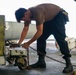 Sailor checks chains on a jet aboard USS Carl Vinson