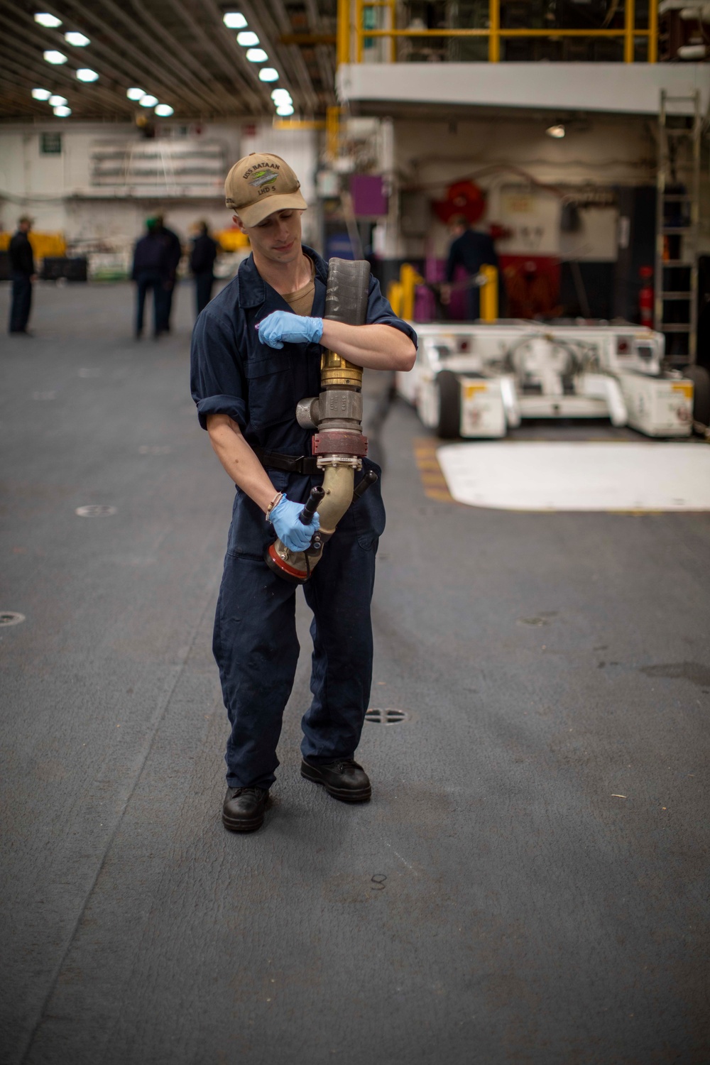 USS BATAAN Sailor conducts preservation maintenance