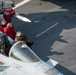 Sailor Cleans The Canopy Of A Super Hornet