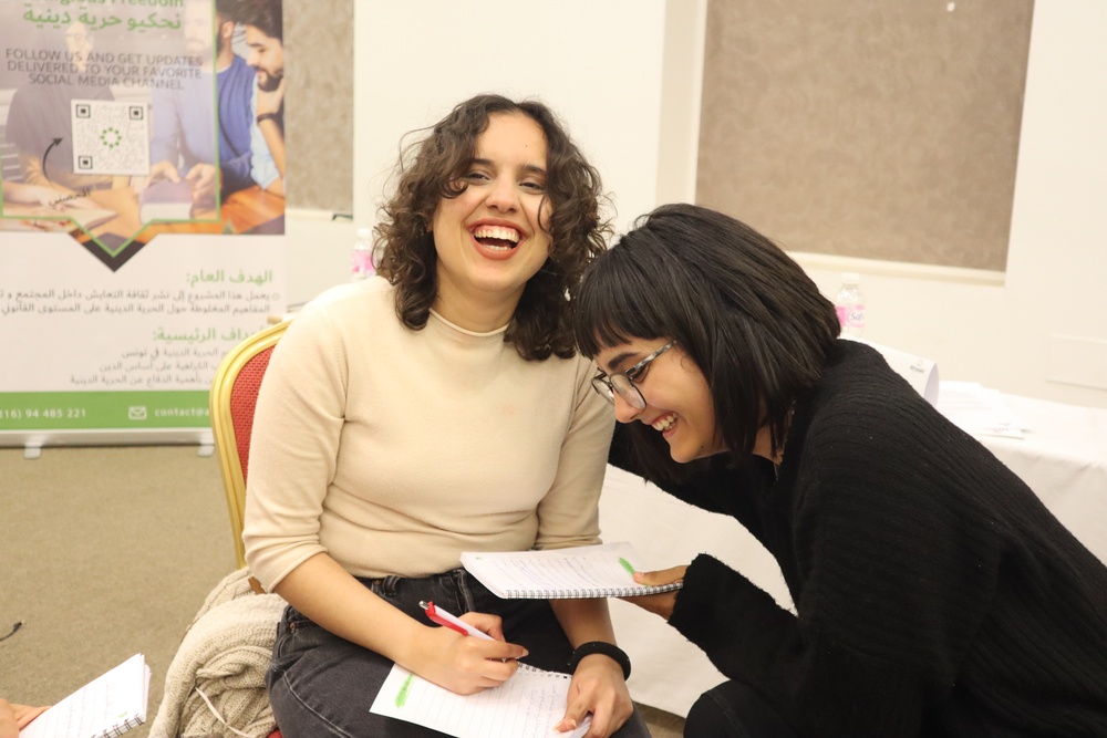 Two Tunisian Youth Women Laugh on the Sidelines of a USAID-Funded Let’s talk about Religious Freedom Workshop