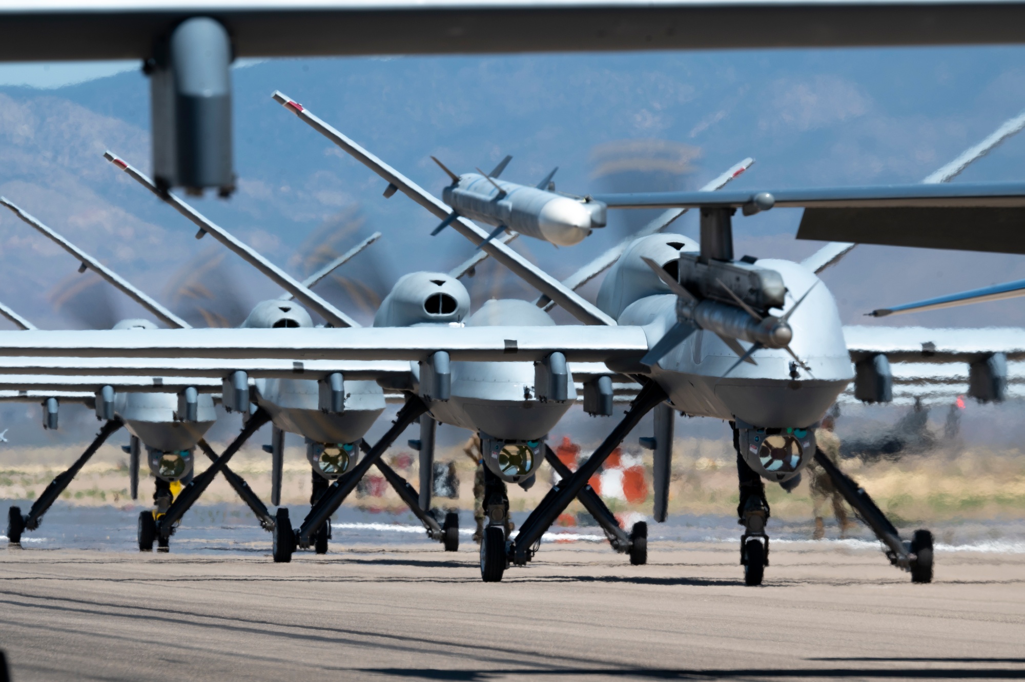 Forty nine MQ-9 Reapers and F-16 Vipers assigned to the 49th Wing line up on the runway during an elephant walk at Holloman Air Force Base, New Mexico, April 21, 2023.