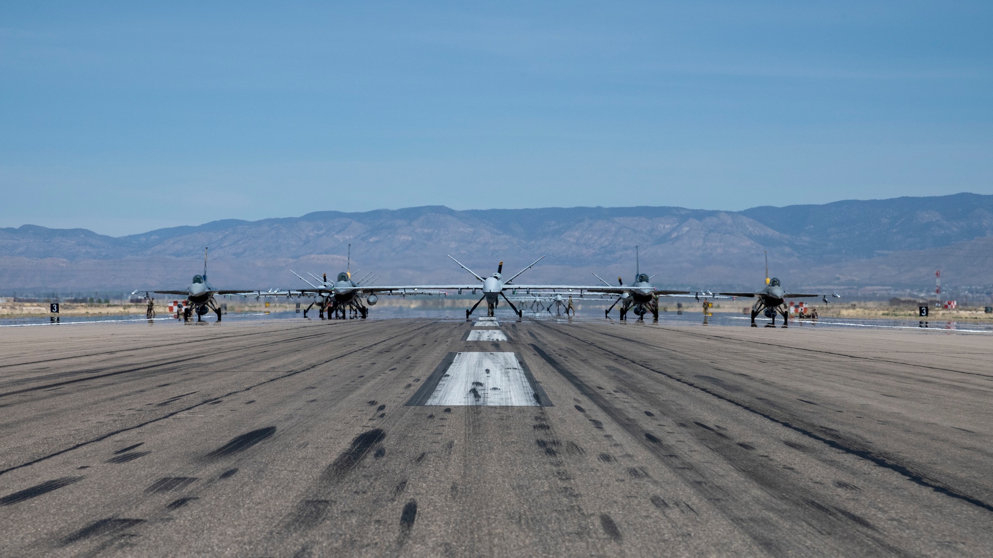 Forty-nine F-16 Vipers and MQ-9 Reapers assigned to the 49th Wing line up on the runway during an elephant walk at Holloman Air Force Base, New Mexico, April 21, 2023.