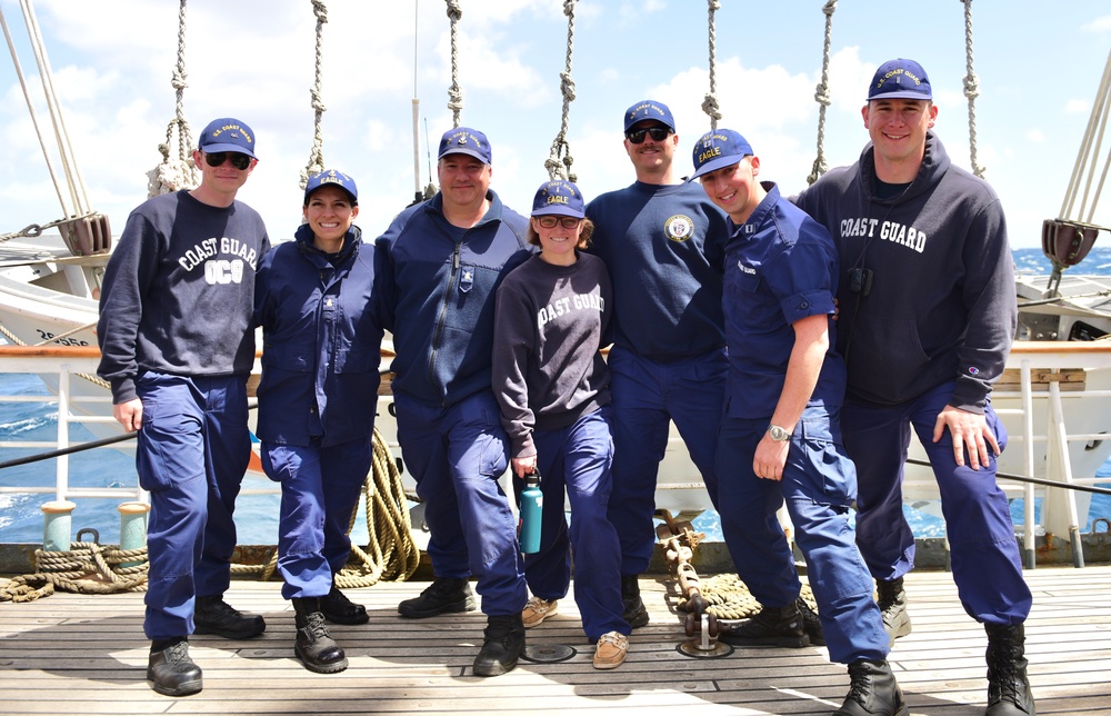 USCGC Eagle personnel, all with connections to the USCGC Mackinaw, pose for a group photo while underway in the Atlantic Ocean