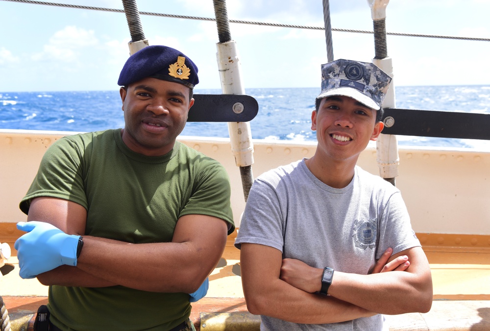 Foreign military personnel aboard USCGC Eagle pose for a photo in the Atlantic Ocean