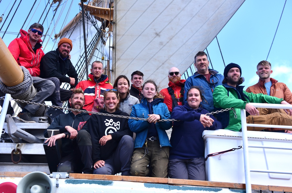 Mariners with Tall Ships America pose for a group photo aboard USCGC Eagle in the Atlantic Ocean