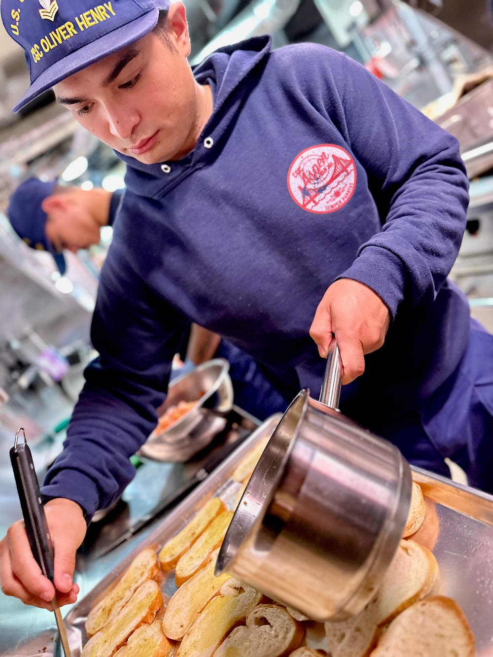 Petty Officer 1st Class Joshua Pablo prepares the noon meal