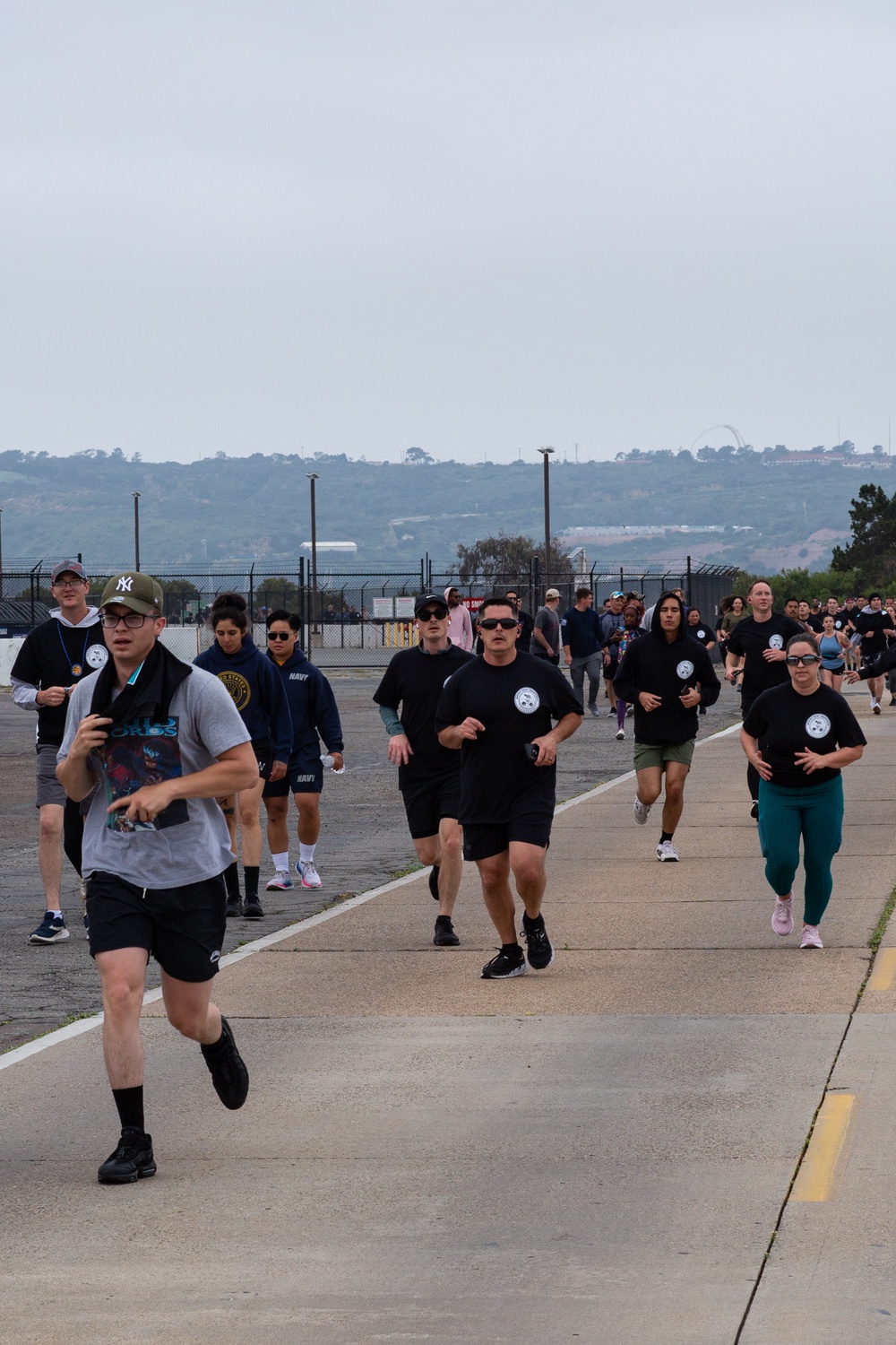 Service members and civilians participate in a SAPR Awareness 5K run