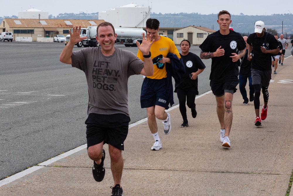 Service members and civilians participate in a SAPR Awareness 5K run