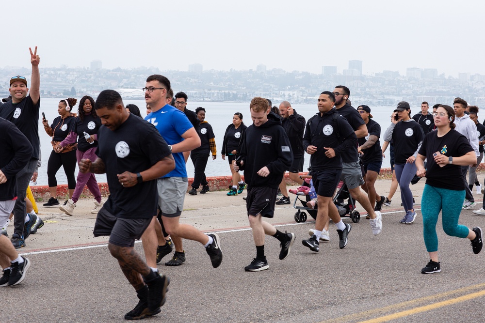 Service members and civilians participate in a SAPR Awareness 5K run