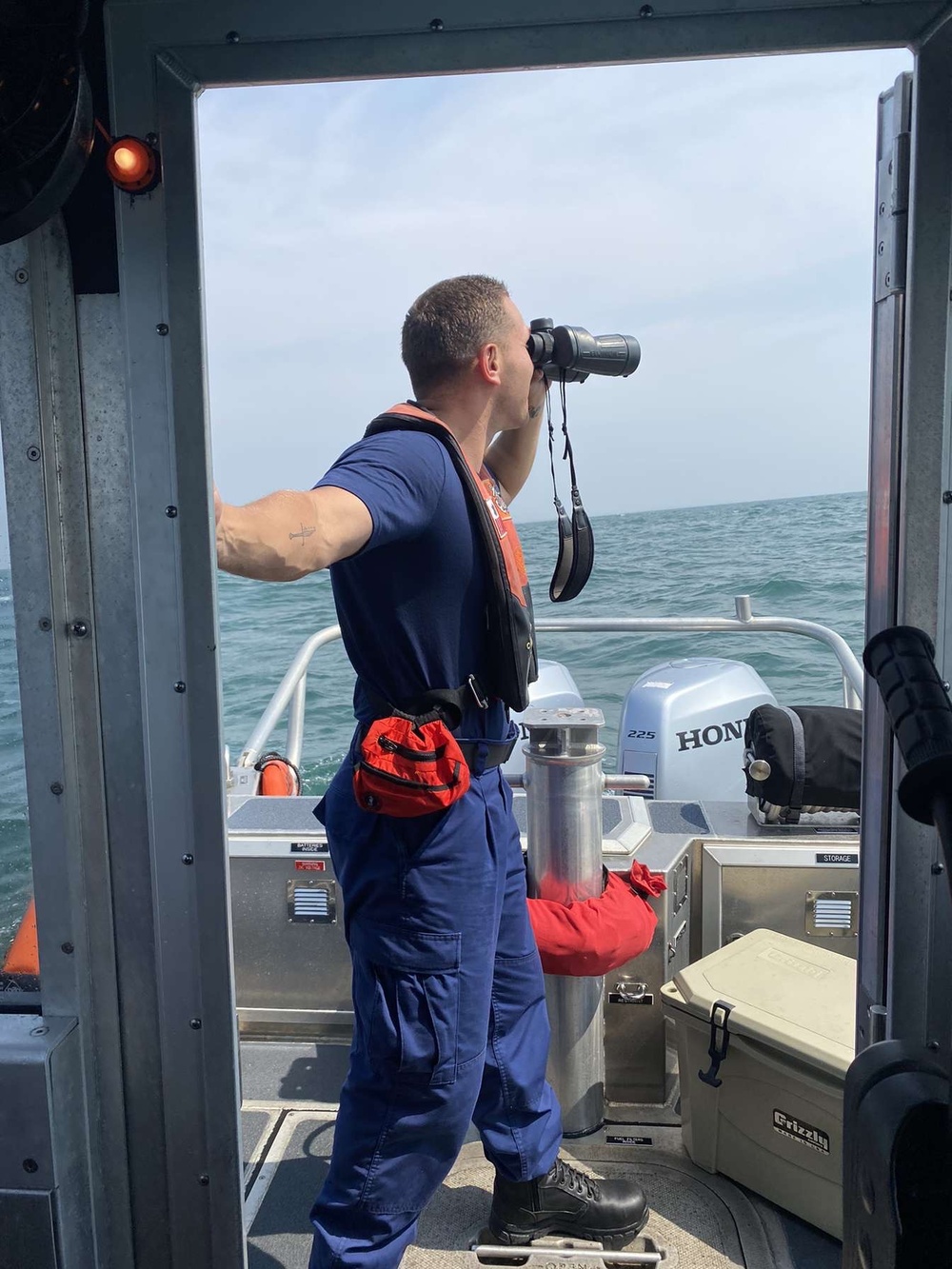 A Coast Guard Station Freeport crewmember looks through binoculars during a search for a missing swimmer on May 6, 2023 near Surfside Beach, Texas. Sector Houston-Galveston watchstanders coordinated a search with Coast Guard Station Freeport boat crews and Coast Guard Air Station Houston aircrews for a missing 19-year-old male swimmer. (Courtesy photo)