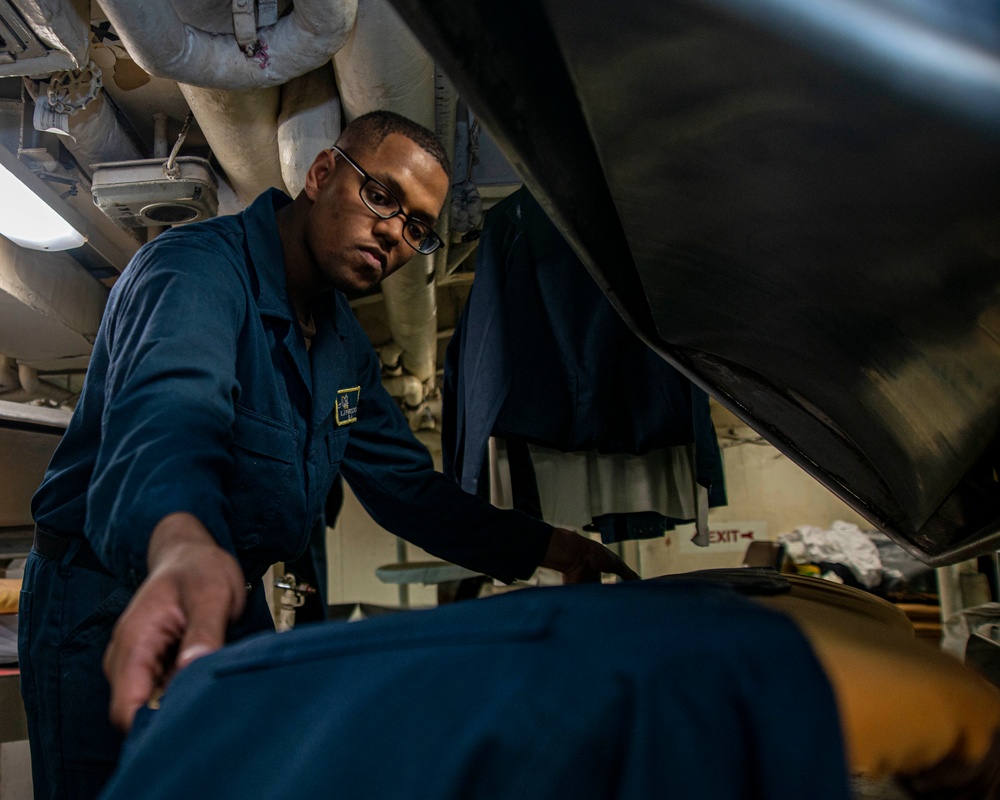 Sailor Checks The Crease Of Coveralls