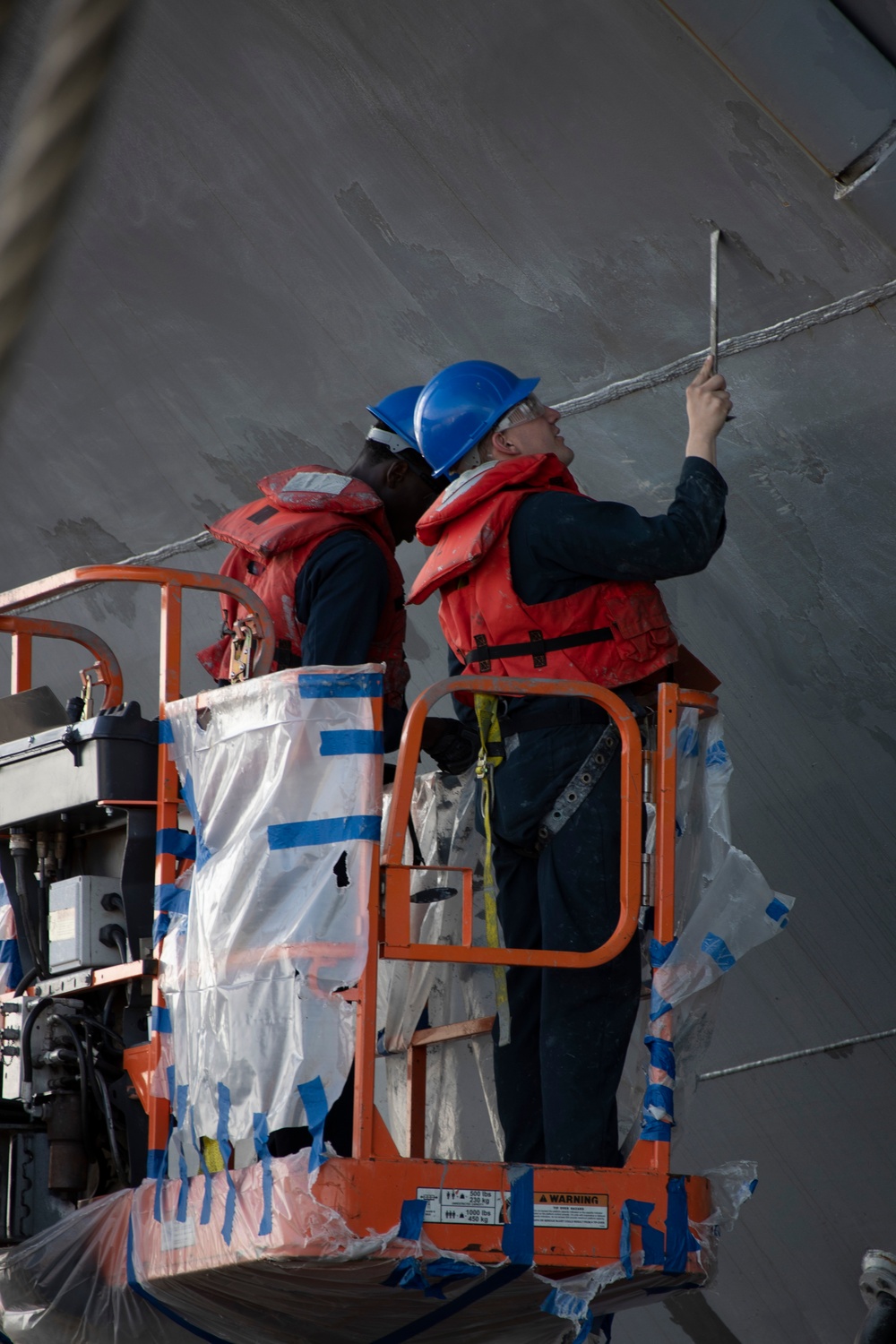 USS Tripoli Sailors Continue To Paint The Ship’s Hull During SRA