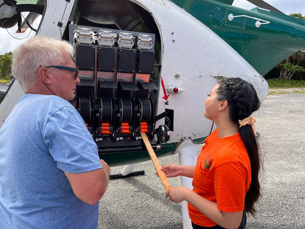 USDA staff prep an automated bait dispenser in a UH-6 helicopter