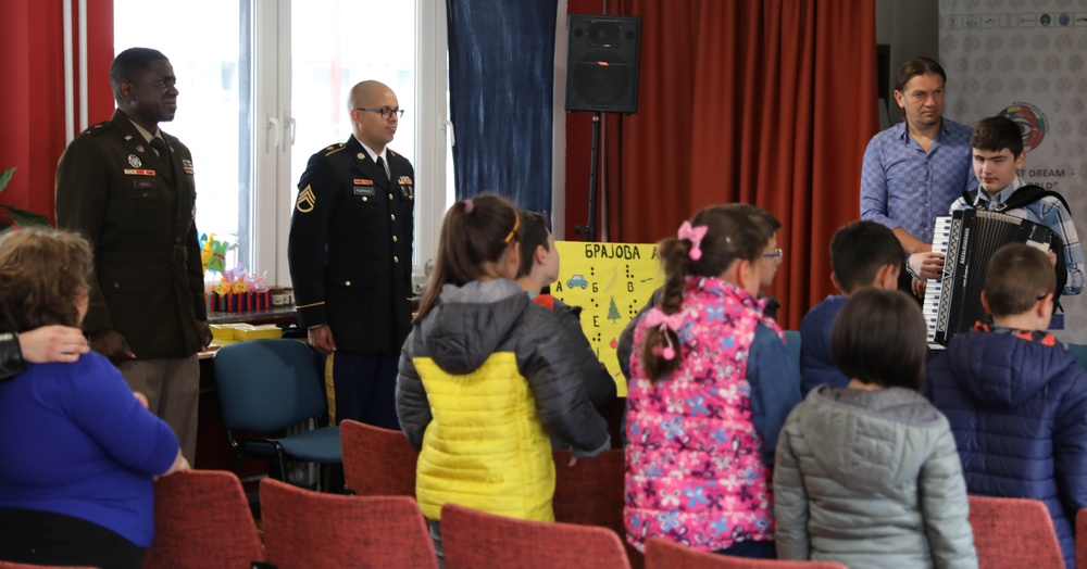 U.S. Army 1st Lt. Jackel Smalls and Staff Sgt. Jonathan Rodriguez listen to the U.S. National Anthem at a cultural exchange event