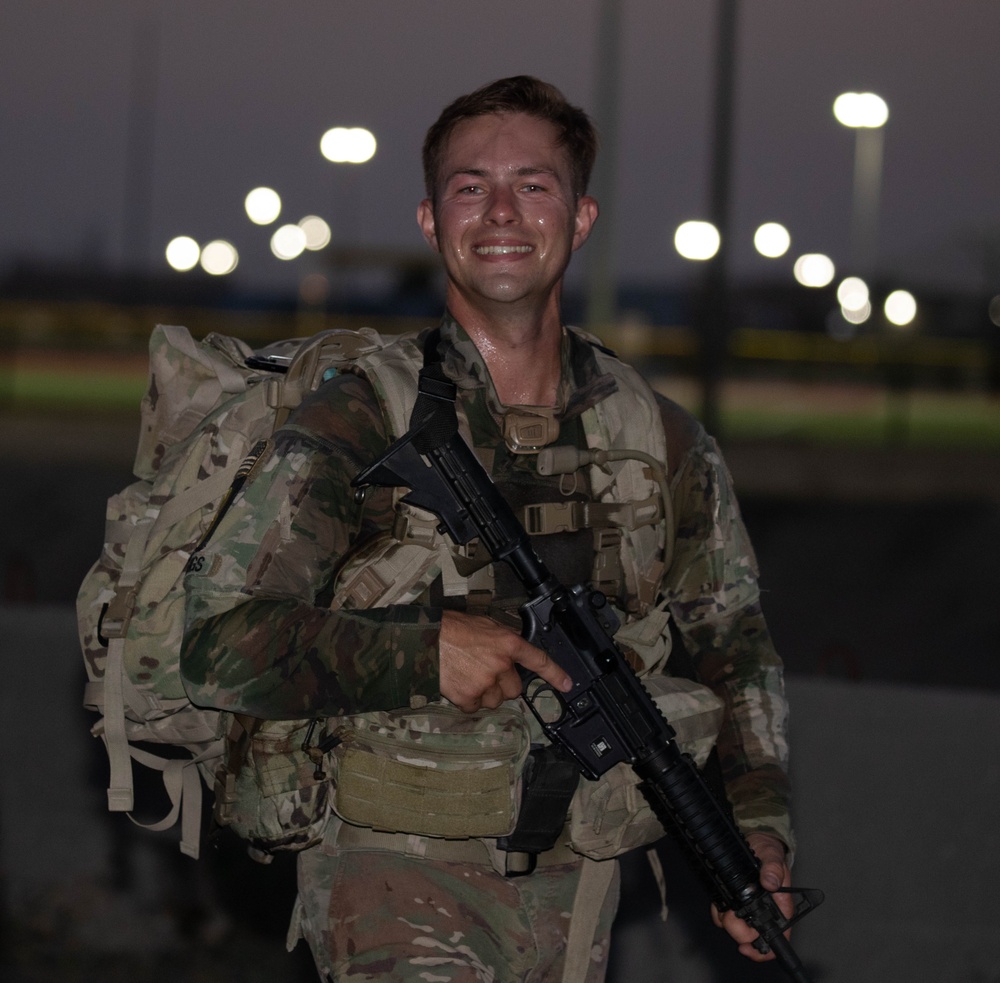 Squad Leader smiles during 8-mile ruck march during USARCENT Best Squad Competition 2023