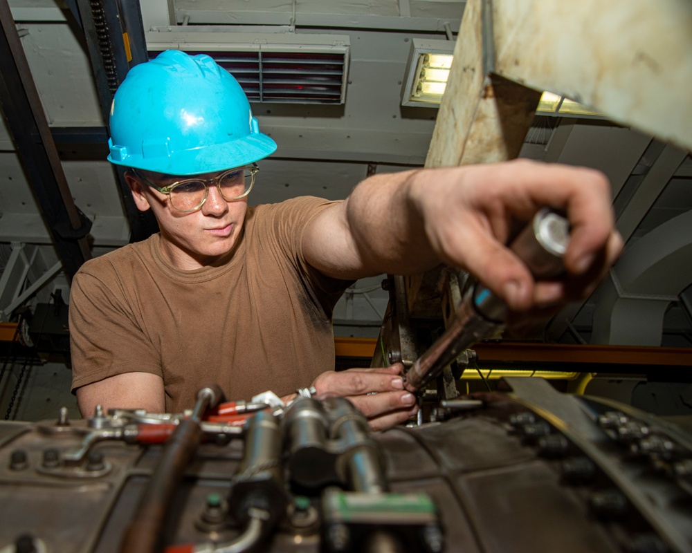 Sailor Tightens Bolts On Jet Engine Using Torque Wrench