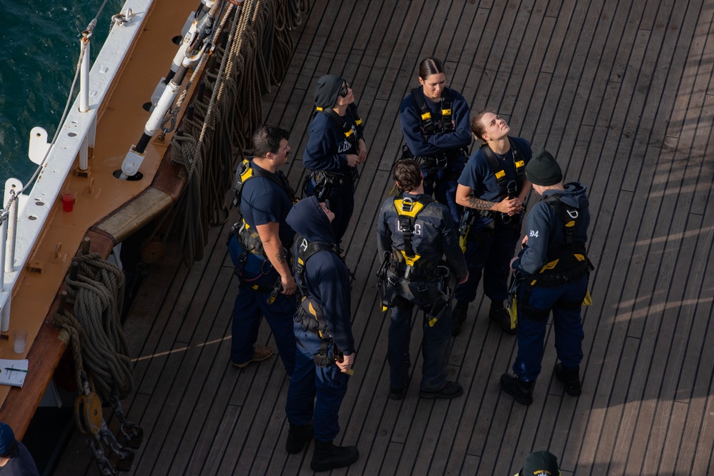 USCGC Eagle crew members prepare to climb the mast