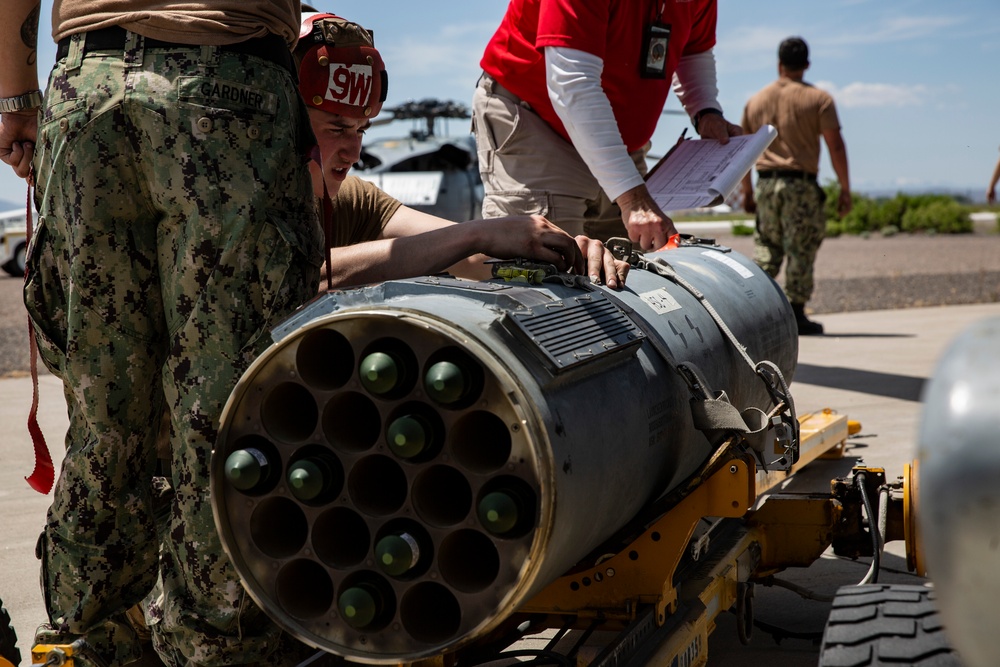 Aviation Ordnanceman mount LAU-61 G/A Digital Rocket Launcher onto an MH-60S