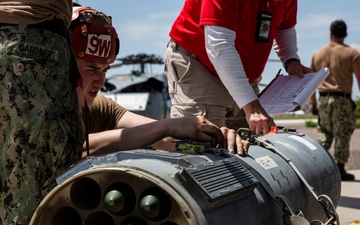 Aviation Ordnanceman mount LAU-61 G/A Digital Rocket Launcher onto an MH-60S