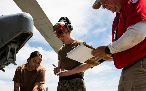 Aviation Ordnanceman mount LAU-61 G/A Digital Rocket Launcher onto an MH-60S