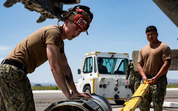 Aviation Ordnanceman mount LAU-61 G/A Digital Rocket Launcher onto an MH-60S