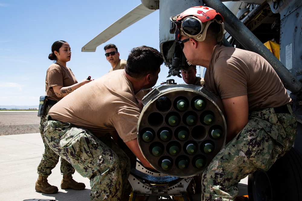 Aviation Ordnanceman mount LAU-61 G/A Digital Rocket Launcher onto an MH-60S