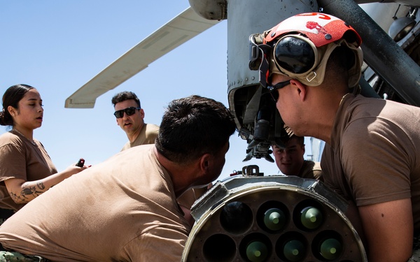 Aviation Ordnanceman mount LAU-61 G/A Digital Rocket Launcher onto an MH-60S