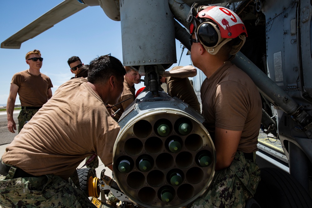 Aviation Ordnanceman mount LAU-61 G/A Digital Rocket Launcher onto an MH-60S