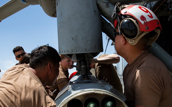 Aviation Ordnanceman mount LAU-61 G/A Digital Rocket Launcher onto an MH-60S