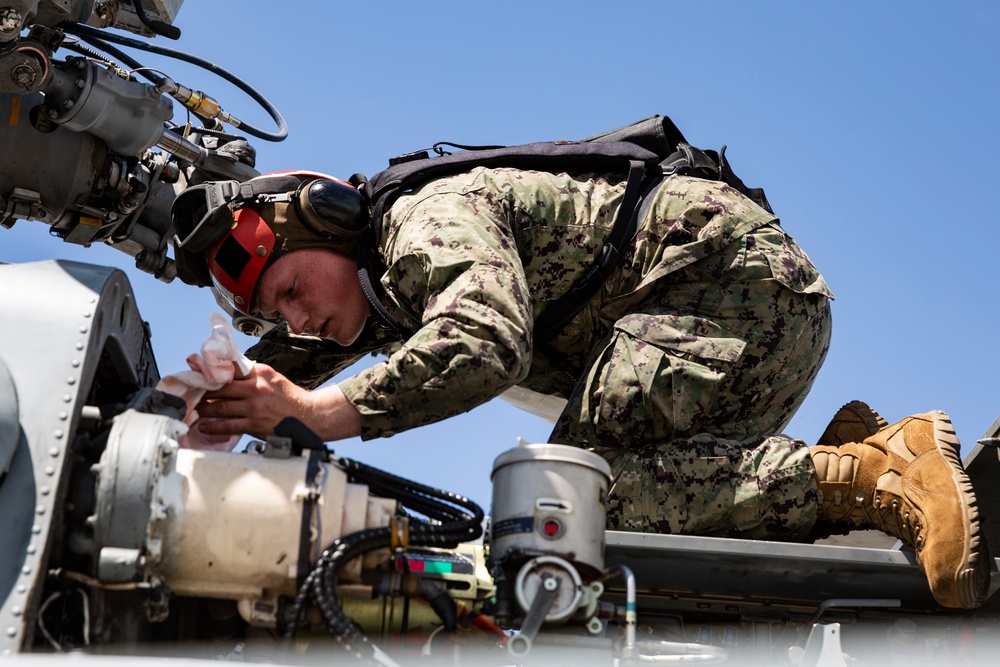 Aviation Ordnanceman mount LAU-61 G/A Digital Rocket Launcher onto an MH-60S