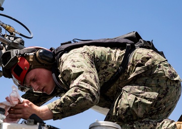 Aviation Ordnanceman mount LAU-61 G/A Digital Rocket Launcher onto an MH-60S