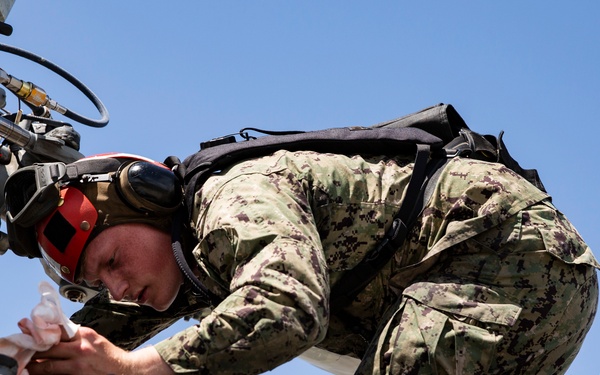 Aviation Ordnanceman mount LAU-61 G/A Digital Rocket Launcher onto an MH-60S