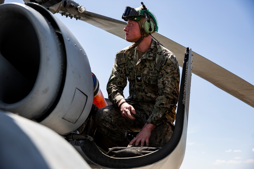 Aviation Ordnanceman mount LAU-61 G/A Digital Rocket Launcher onto an MH-60S