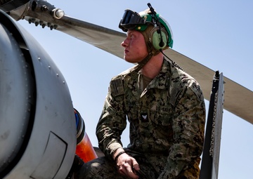 Aviation Ordnanceman mount LAU-61 G/A Digital Rocket Launcher onto an MH-60S