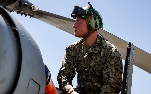 Aviation Ordnanceman mount LAU-61 G/A Digital Rocket Launcher onto an MH-60S