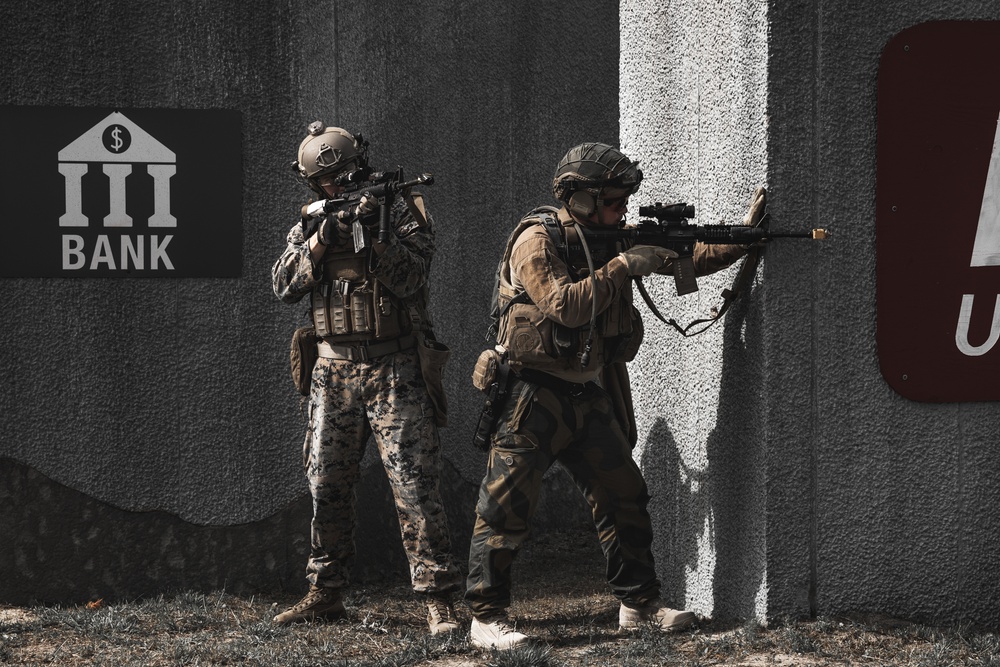 U.S. Marines run through the Outdoor Infantry Immersion Trainer with foreign allied Nations